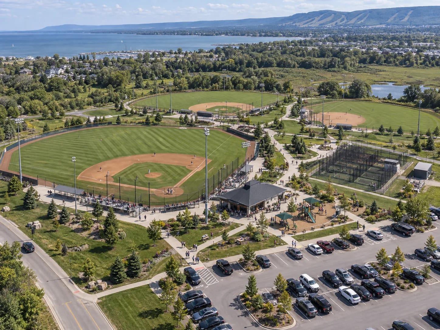 The same complex from further out — diamonds, practice fields and parking together — under the line a greater playground.